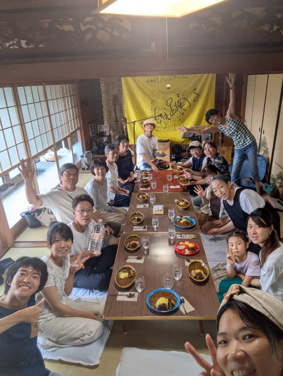 長テーブルを囲んで食事をしながら笑顔で集まる音とご飯の会の参加者